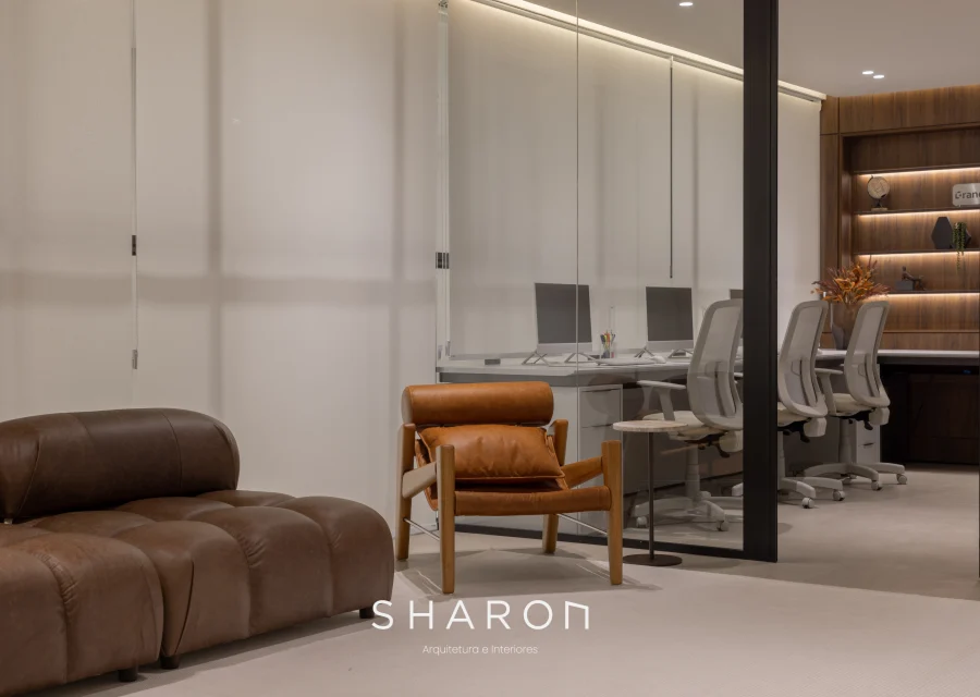 Sala de espera do projeto Grandino, com poltronas de couro e divisória de vidro.